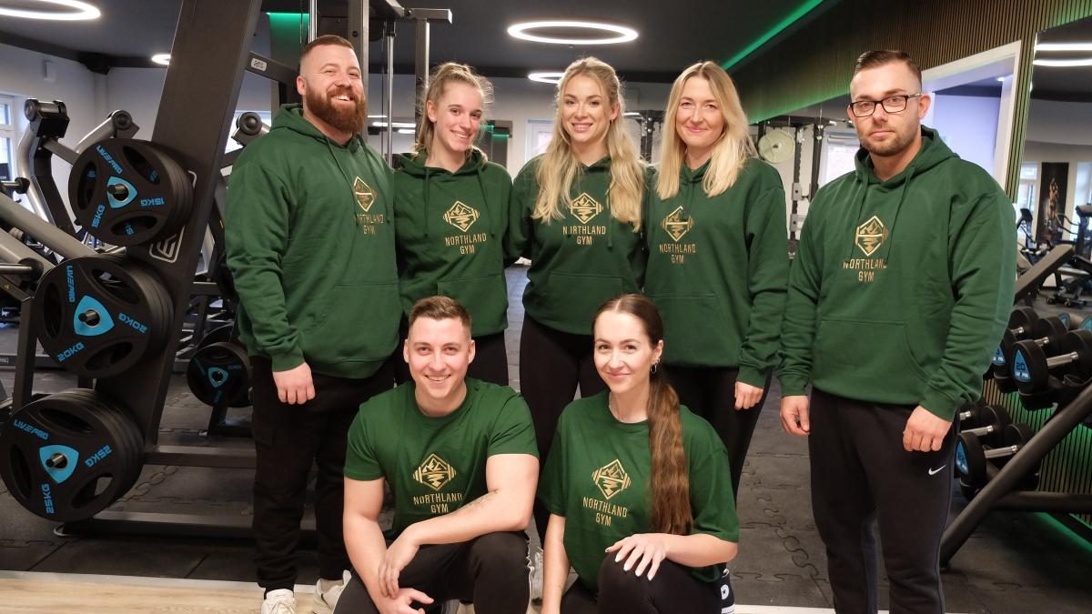 Das Team des Northland Gym in grünen Team-Hoodies auf der Trainingsfläche